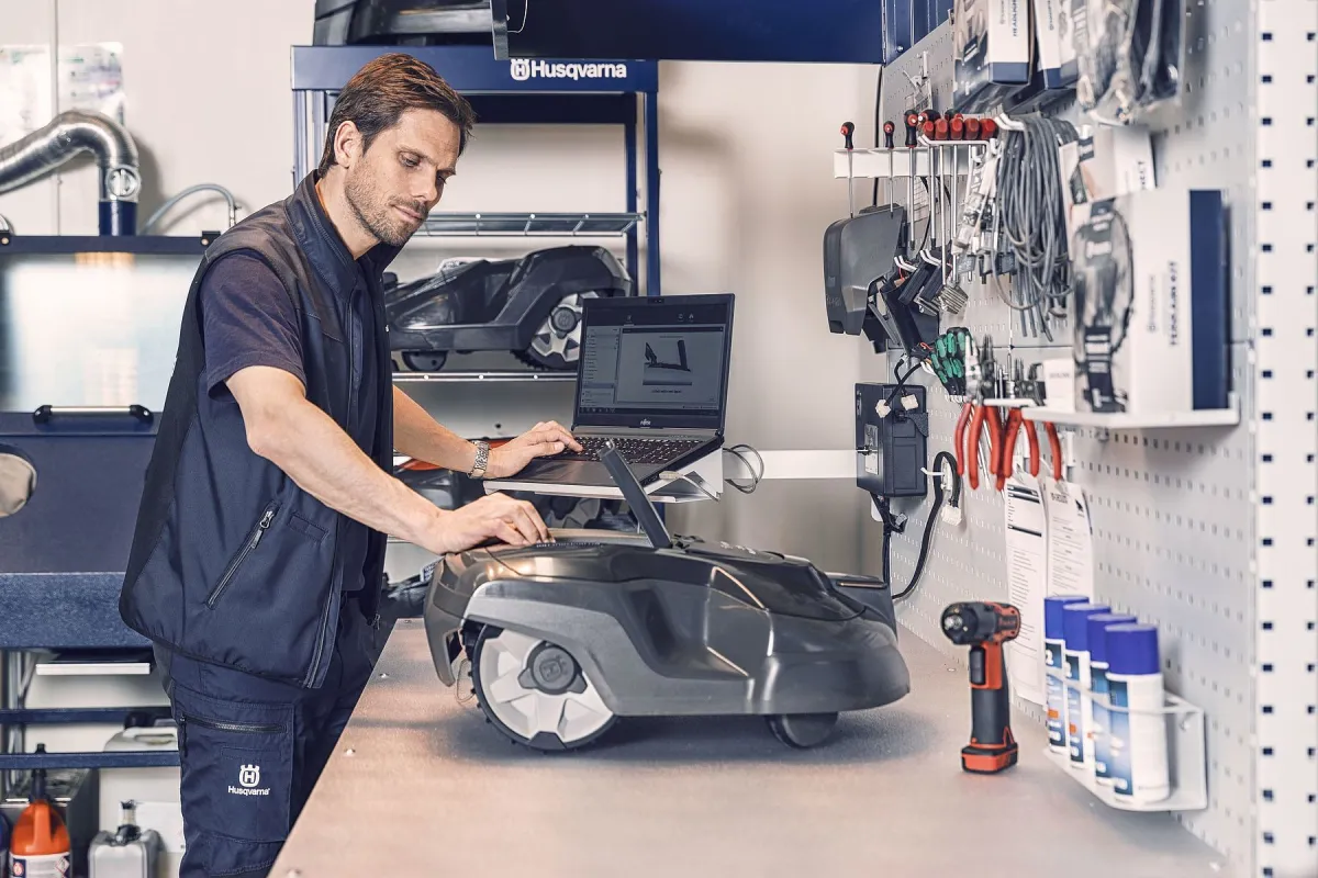 Techniker wartet einen Automower in der Werkstatt